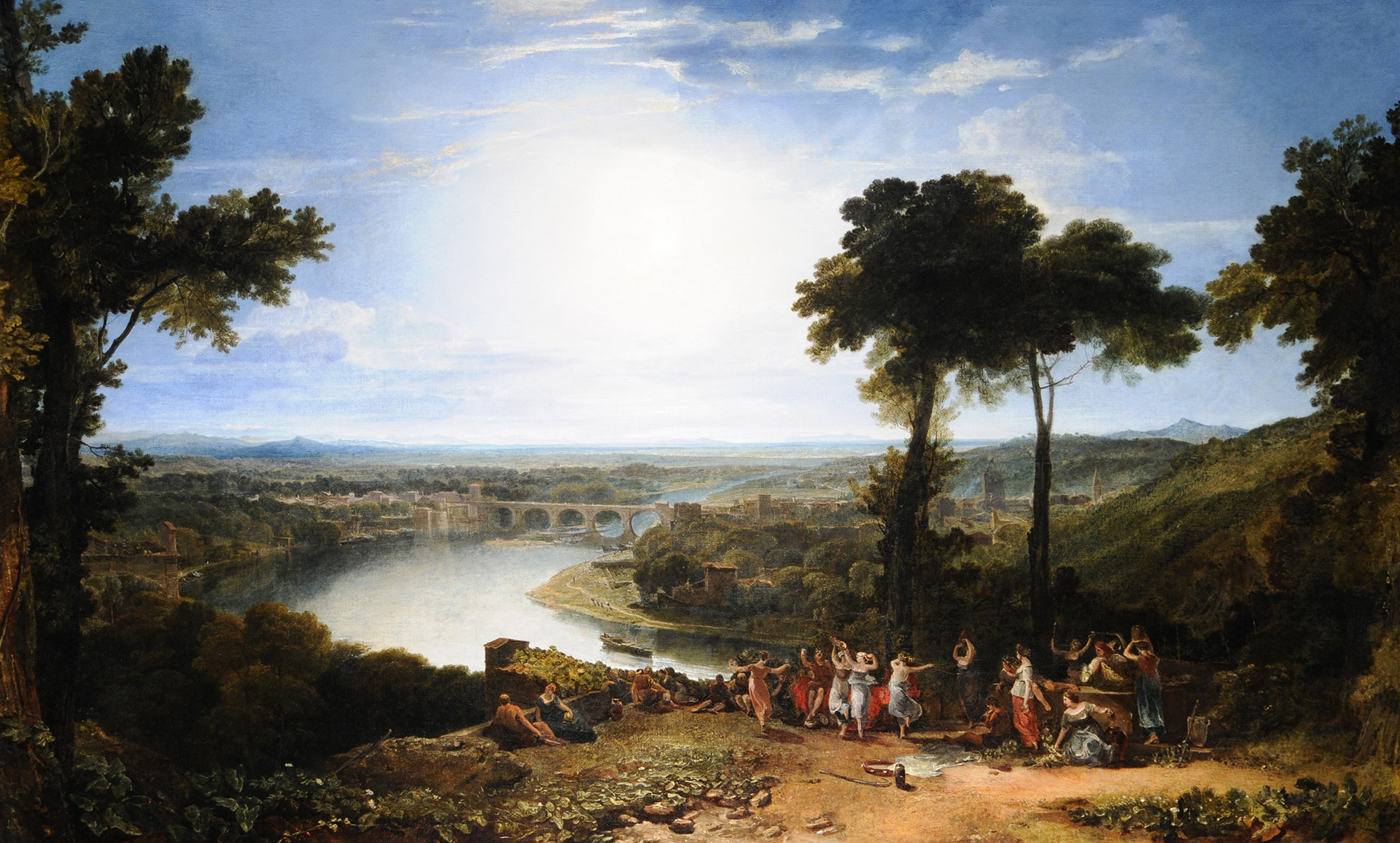 An oil painting of a rural landscape on a sunny day. In the foreground figures dance and celebrate on a hillside.  In the background there is a river, trees, buildings and a bridge, with mountains in the distance. 